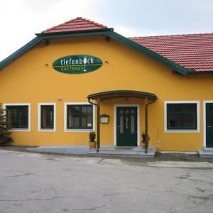 Gelbes Gebäude mit rotem Ziegeldach und zentralem Eingang, vermutlich Gasthaus oder Gemeindezentrum