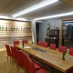 Konferenzraum mit langem Holztisch und roten Stühlen unter Holzdecke
