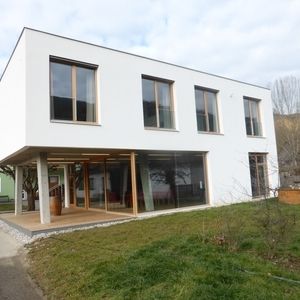 Modernes Wohnhaus mit Flachdach und Holzverkleidung im Erdgeschoss