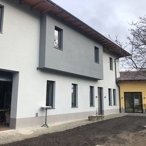 Zweigeschossiges renoviertes Gebäude mit weißer Putzfassade
