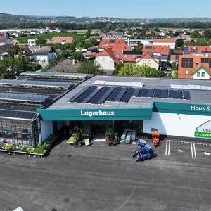 Luftaufnahme eines Gebäudes mit Photovoltaikanlage in städtischer Umgebung