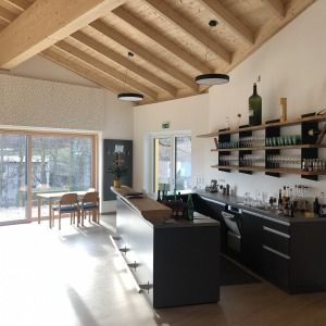 Große Wohnküche mit Holzdecke und bodentiefen Fenstern
