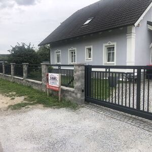 Schlichtes schwarzes Metalltor vor Einfamilienhaus