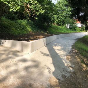 Betonzaun mit abgerundeter Einfahrt