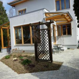 Weg mit grauem Pflaster und Holzpergola im Vorgarten