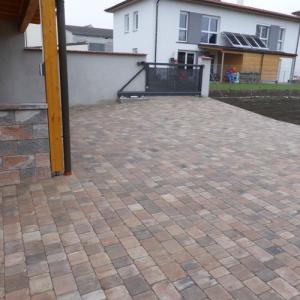 Bunter Pflasterbelag unter Holzcarport