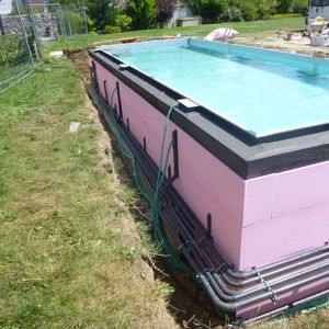 Rechteckiger Pool mit rosa Isolierung im Rohbau