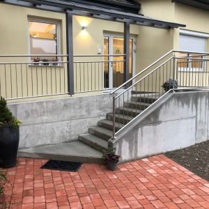 Außentreppe mit Geländer und rotem Pflaster