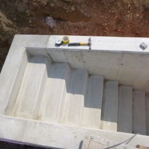Breite Betontreppe mit seitlicher Mauer