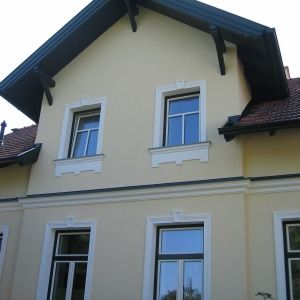 Sanierter Altbau mit gelber Fassade, weißen Fensterrahmen und Dachgeschossgaube