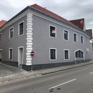 Saniertes Wohnhaus mit grauer Fassade in der Dämmerung