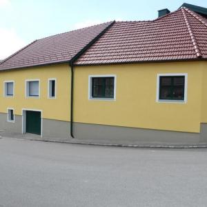Gelb gestrichenes Haus mit energetischer Fassadensanierung