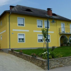 Klassisches Einfamilienhaus mit gelber Fassade, rotem Ziegeldach und Ziergiebel